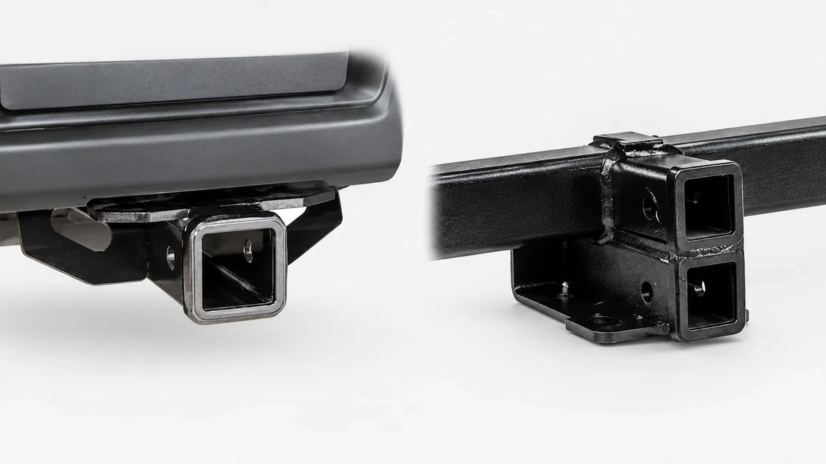 Single receiver beneath a Ford pickup bumper beside the two stacked receiver openings of a TorkLift SuperHitch.